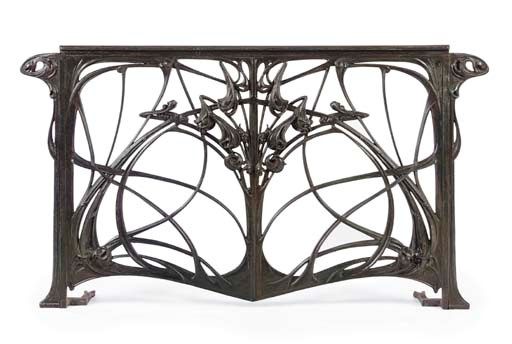 an ornate metal table with birds on it's back and two leaves in the center