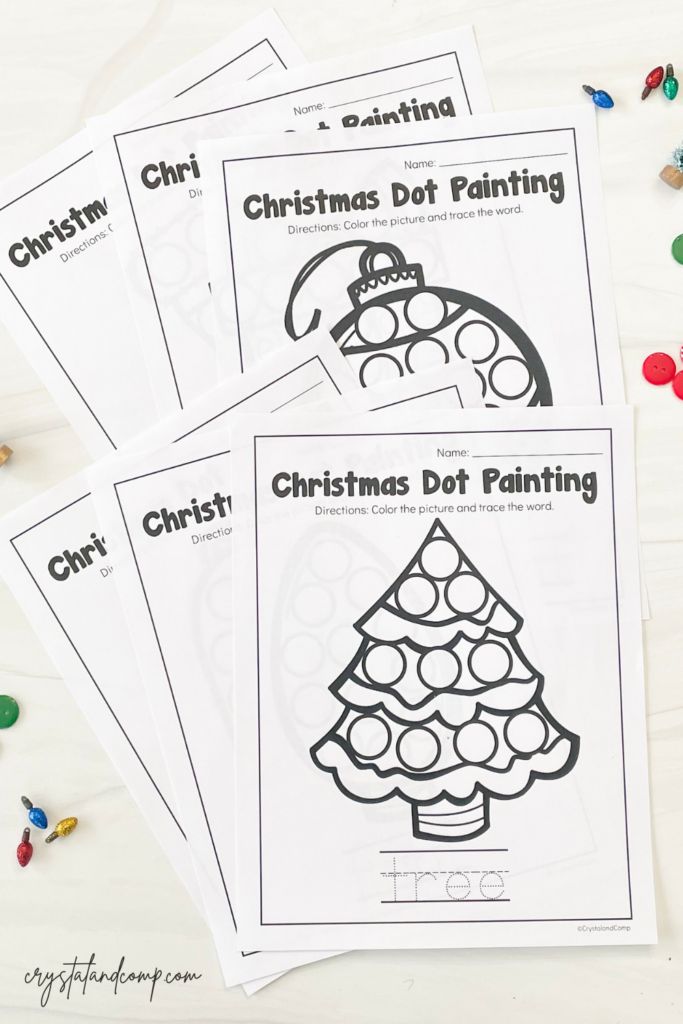 four christmas dot painting pages with candy on the table next to them and some crayons