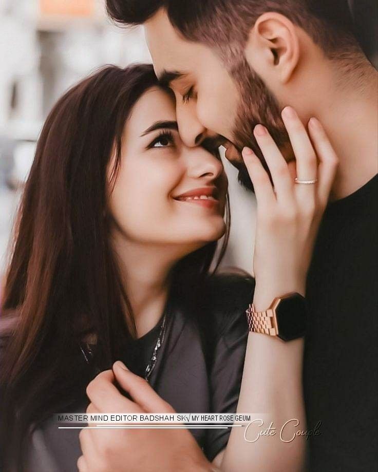 a man and woman standing next to each other with their hands on the foreheads