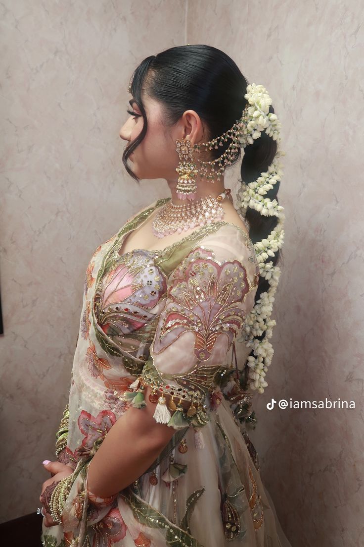 a woman in an elaborate dress with flowers on her head and hair pinned back to the side