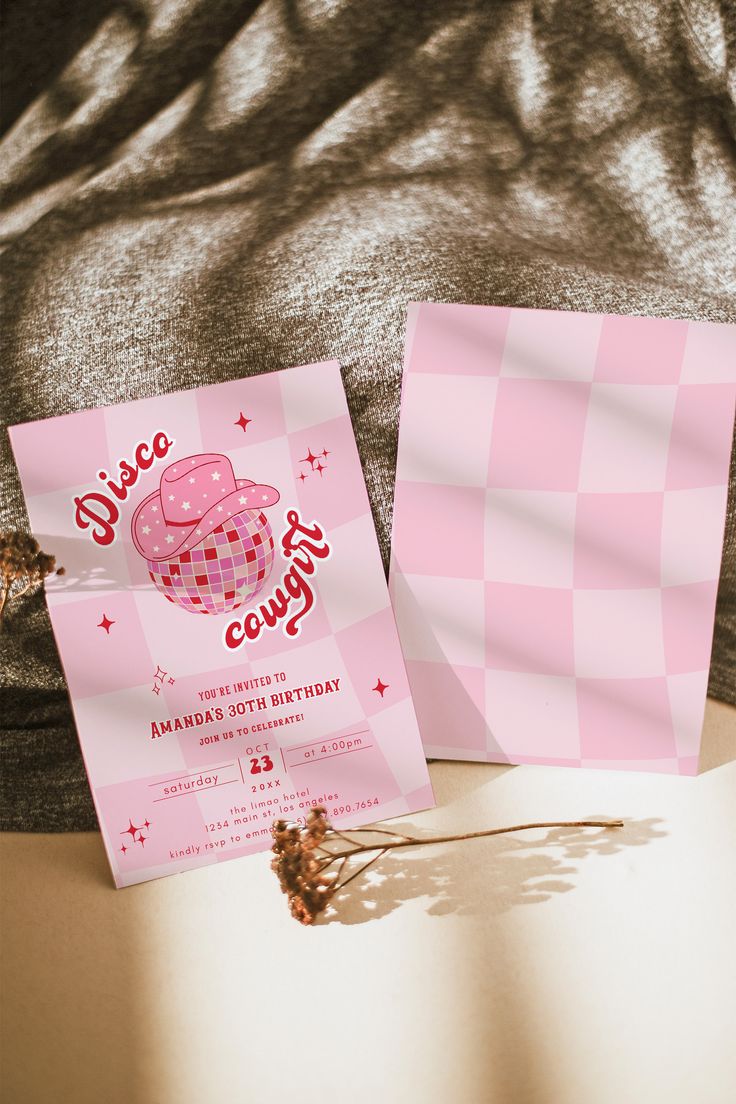 a pink and white checkered paper with a cupcake on it next to a card