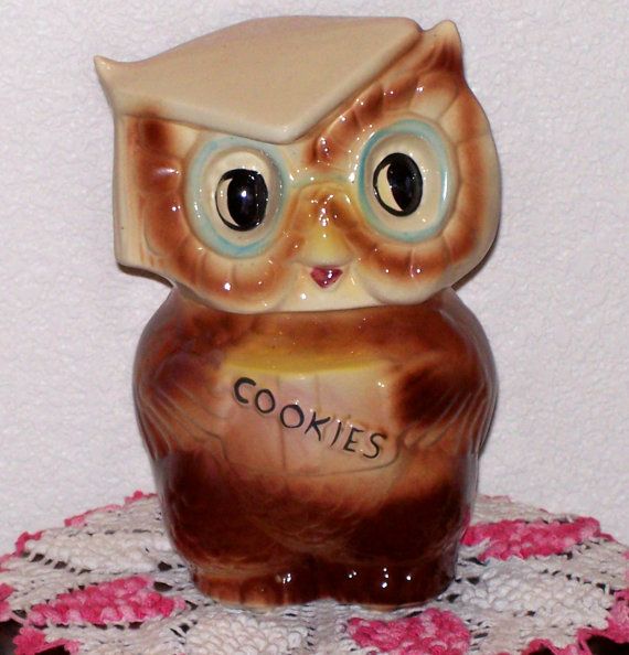 an owl figurine sitting on top of a doily with the word cookies written on it