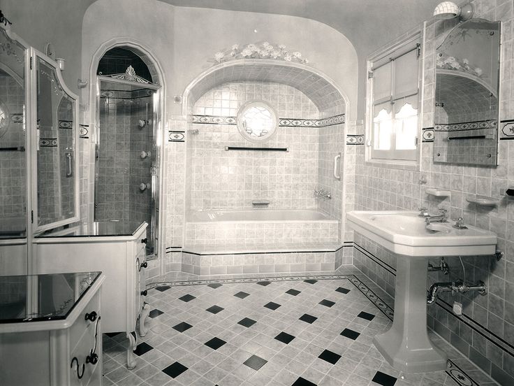 this bathroom has black and white tiles on the floor, walls, and tubs