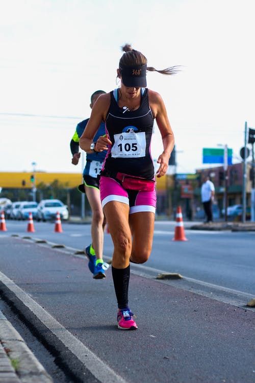 a woman running down the road in a race