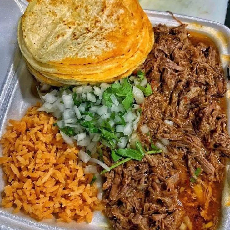 a plastic container filled with rice, meat and veggies next to tortillas