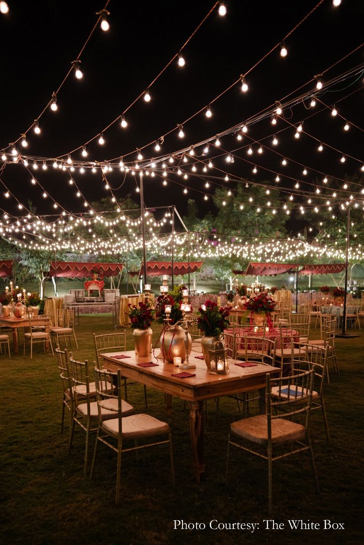 an outdoor event with string lights and tables