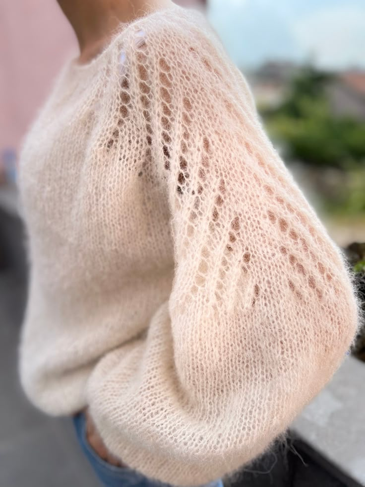 a close up of a person wearing a sweater and jeans with her hand on her hip