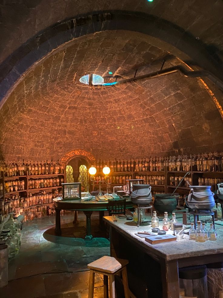 the inside of a wine cellar with many bottles on shelves and tables in front of it