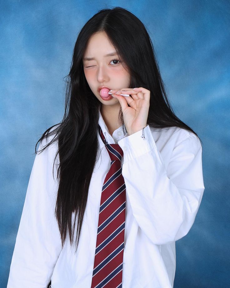 a young woman in a tie is posing for a photo with her mouth open and tongue out