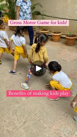 a group of children playing with a ball on the ground