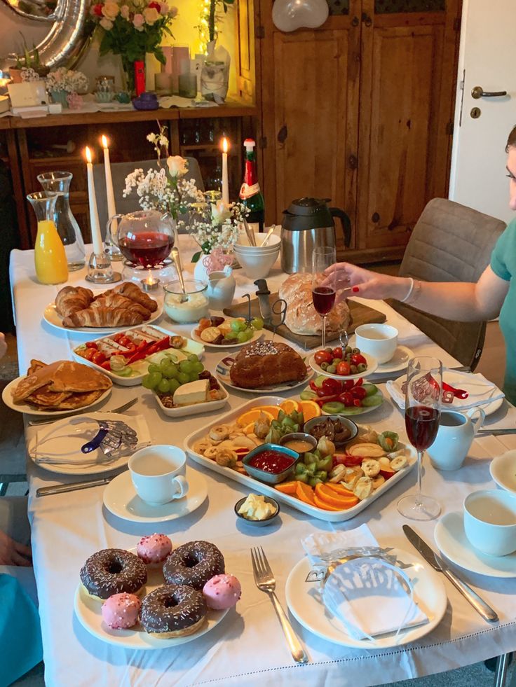 a woman sitting at a table filled with food