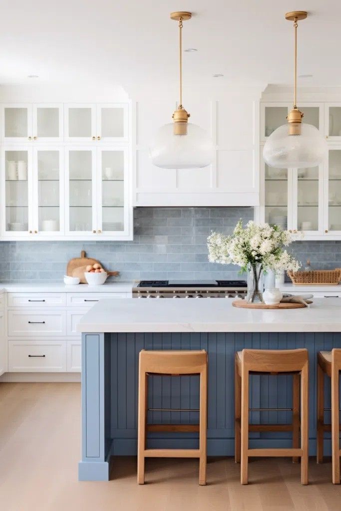 a kitchen with white cabinets and blue island