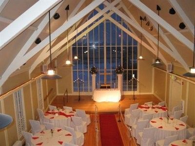 a room filled with tables and chairs covered in white tablecloths next to a large window