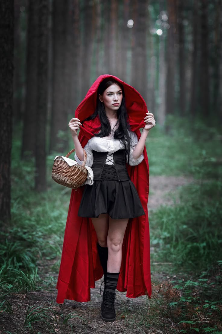 a woman dressed as a red riding hood in the woods