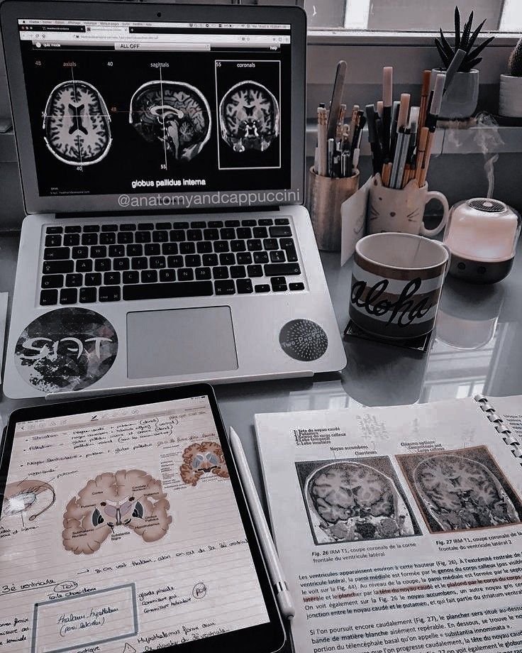 an open laptop computer sitting on top of a desk next to papers and other items