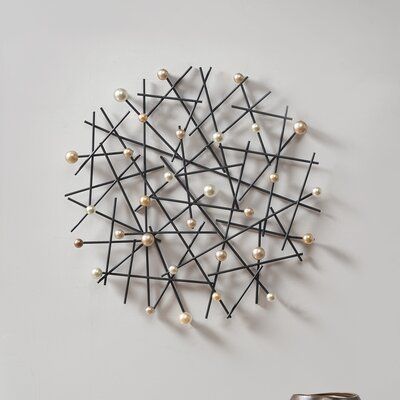 a circular sculpture made out of sticks with pearls on the top and one bead at the bottom