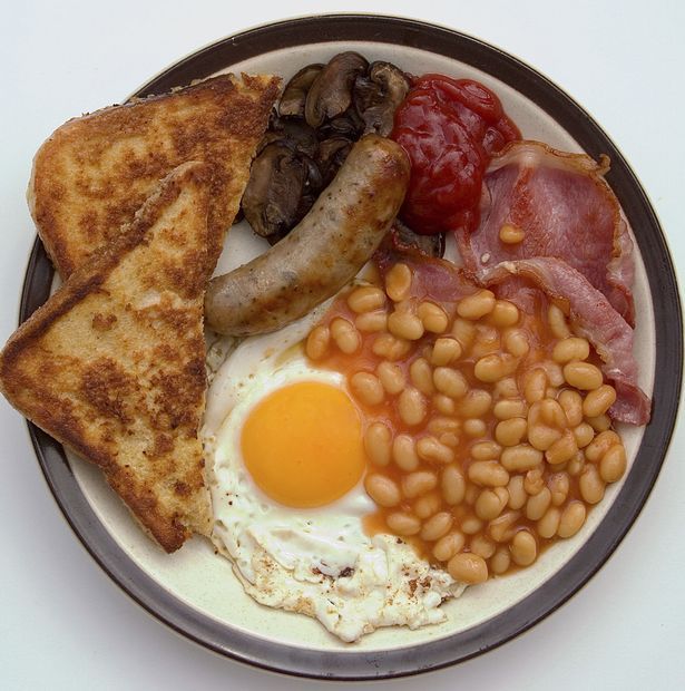 a plate with eggs, toast, beans and sausage