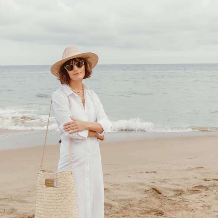 The Salty, our handwoven straw tote bag, embodies the California state of mind - effortless beach style and functional sustainability. Worn over the shoulder, as a crossbody, or styled for a dressier occasion as a straw handbag, the removable leather strap makes the Salty tote your most versatile accessory for summer. The hand-dyed, 100% genuine leather strap and handles in our signature 'salt,' neutral tone and matte gold hardware elevate the Salty straw bag for a chic coastal look. Each handmade bag is unique and may have small imperfections or vary in size and color. All Leah products are responsibly sourced and ethically crafted. 14 x 4.5 x 16 in Imported Elegant Summer Straw Bag For Everyday Use, Elegant Everyday Summer Straw Bag, Elegant Woven Straw Bag For Day Out, Elegant Straw Tote Bag For The Beach, Elegant Summer Beach Bag In Natural Color, Elegant Tote Straw Bag For The Beach, Crossbody Straw Bag With Braided Handles For Day Out, Natural Straw Crossbody Bag For Beach Season, Eco-friendly Crossbody Straw Bag For Beach