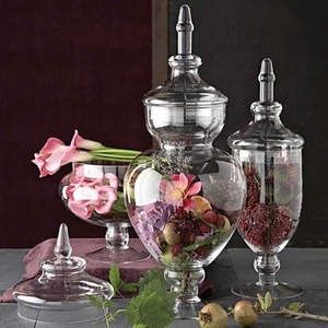 three glass vases with flowers in them sitting on a table next to each other