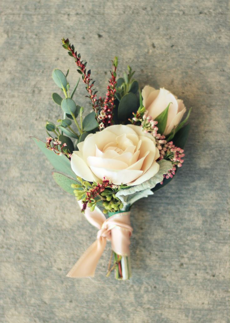 a boutonniere with white roses and greenery