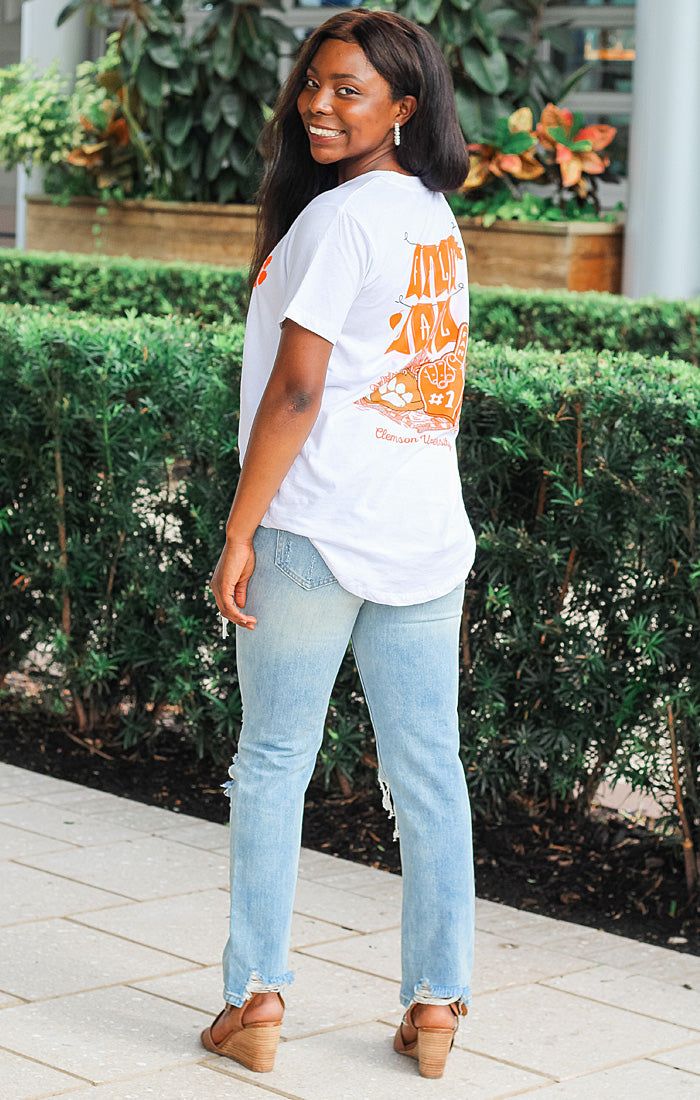 Tailgate for Fall Football Games in The Clemson “Pennant Hand” Classic Tee! It features a “Fall Ball” graphic on the back. It is short sleeve with a scoop neck neckline and is lightweight. Pair with your favorite denim shorts and strappy sandals. Details: *OFFICIALLY LICENSED* Clemson Tigers Scoop neck neckline Short sleeve Full length Lightweight 100% cotton ”Fall Ball” graphic on back True to size Raven is wearing size Small Casual T-shirt With Back Print For Fall, Casual Short Sleeve T-shirt For Game Day, Casual Short Sleeve Game Day T-shirt, Sporty Short Sleeve Tops For Campus, College Style Short Sleeve T-shirt For Game Day, Casual White T-shirt For College, Casual White T-shirt For Campus, Collegiate Short Sleeve Tops For Campus, Casual Graphic Print T-shirt For Campus