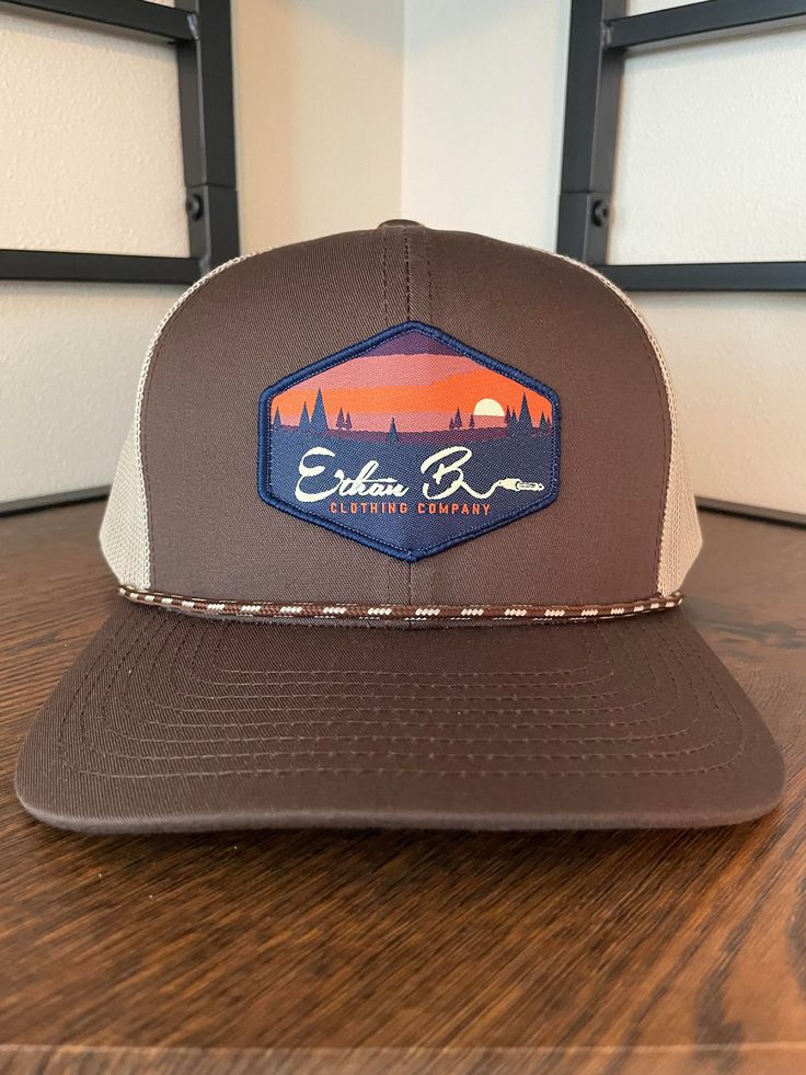 Ethan b. Clothing Co. Sunset hat. Hat color Brown/Khaki Pro-stitched finish CROWN: Mid-Profile, Pro-Model VISOR: Curved CLOSURE: Snapback FABRIC: Cotton Blend, Trucker Mesh Brown Flat Brim Sports Hat, Brown Flat Bill Sports Hat, Sports Flat Bill Hat In Brown, Brown Trucker Hat For Outdoor, Brown Baseball Cap For Outdoor, Khaki Snapback Hat For Outdoor With Flat Bill, Brown Outdoor Baseball Cap, Khaki Flat Bill Snapback Hat For Outdoor, Outdoor Khaki Snapback Hat With Flat Bill