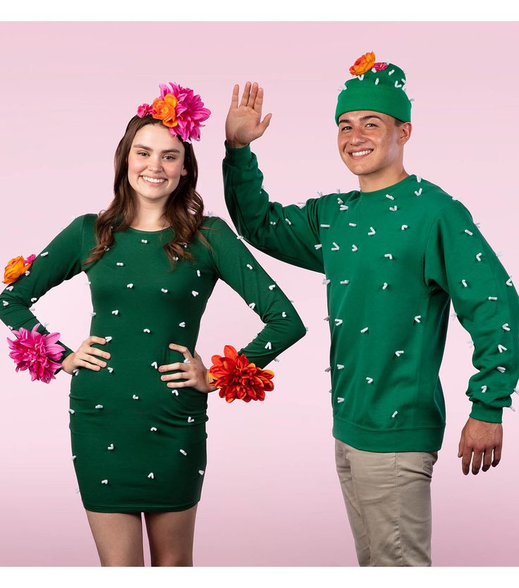 a man and woman dressed in green clothing with flowers on their heads, standing next to each other