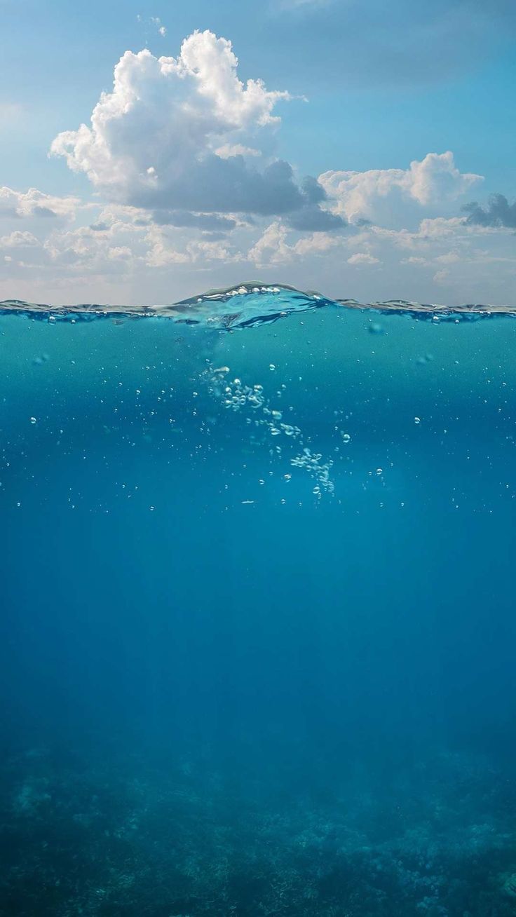 the water is very clear and blue with some clouds above it