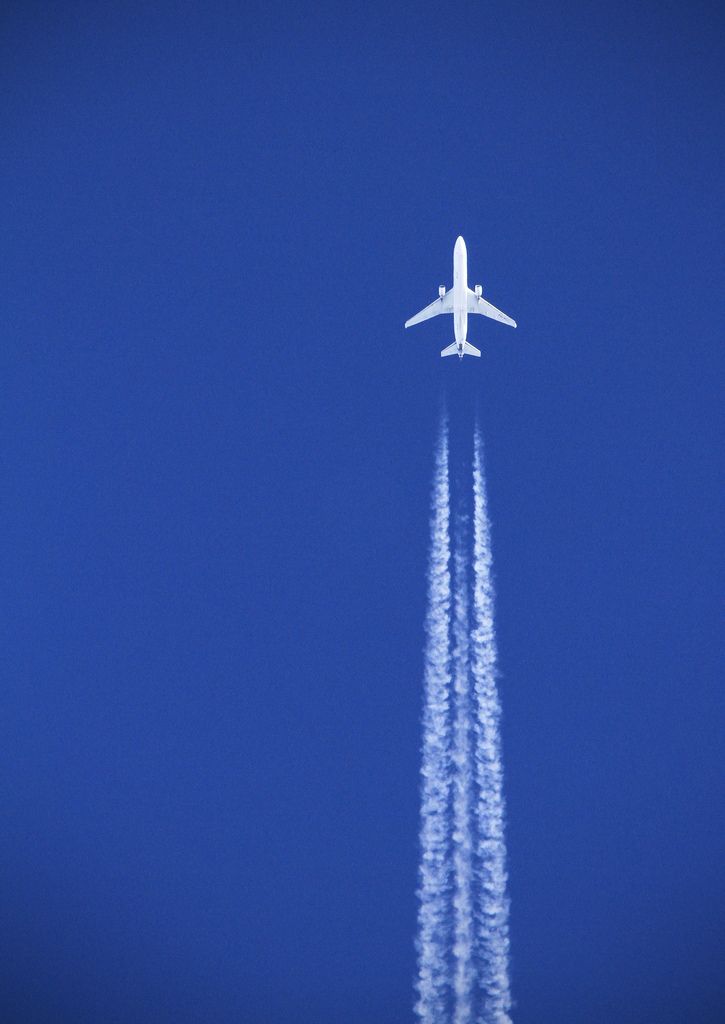 an airplane is flying in the blue sky