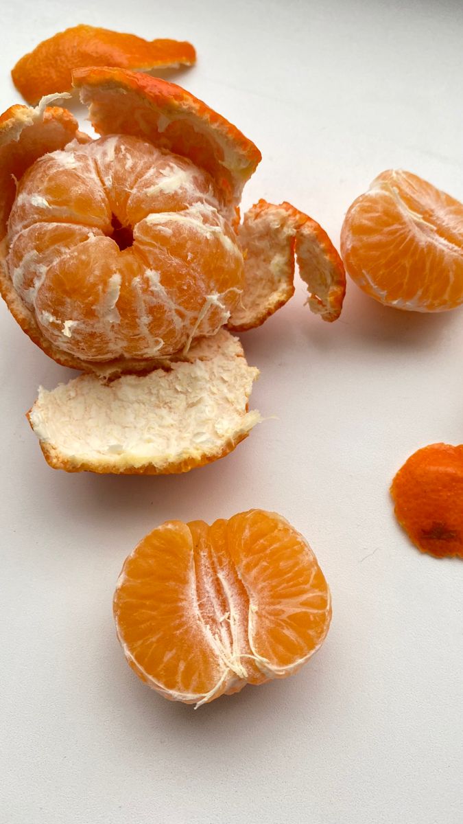 peeled oranges are sitting on a white surface