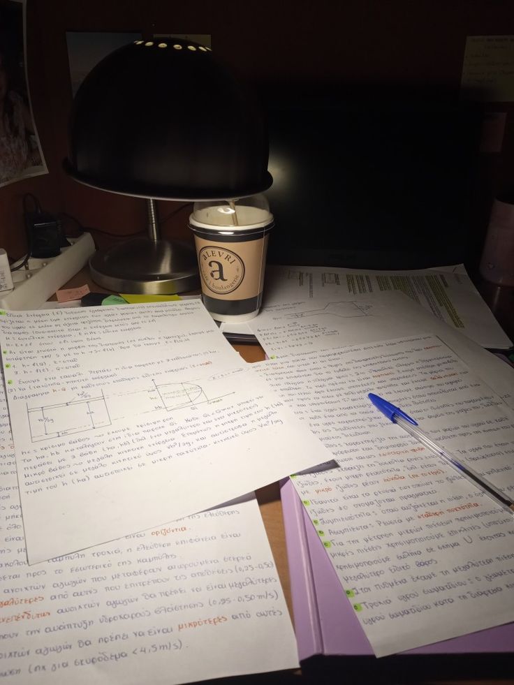 several pieces of paper sitting on top of a desk next to a cup of coffee