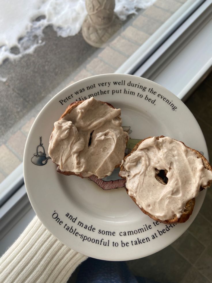 a person holding a plate with two pieces of bread covered in frosting on it