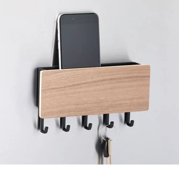 a cell phone and key holder attached to a wall with two phones on it's hooks