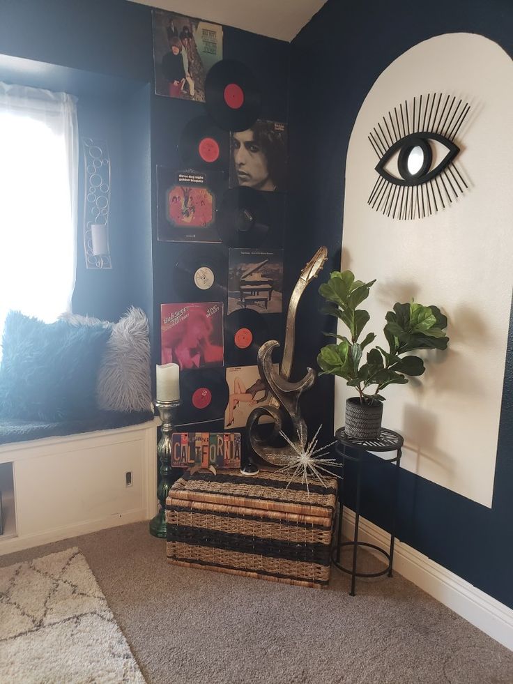 a living room with blue walls and an eye - shaped wall hanging on the wall