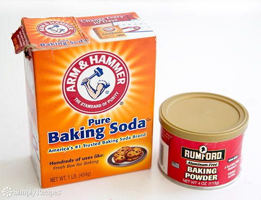 an open box of baking soda next to a can of powdered sugar on a white surface