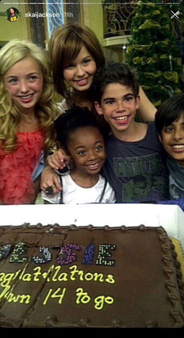 a group of people standing in front of a cake with the words congratulationss written on it