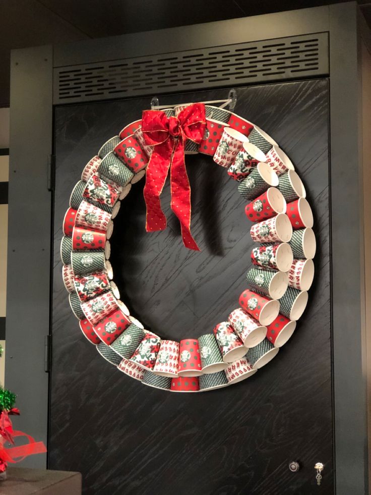 a christmas wreath is hanging on the front door with cups and saucers around it