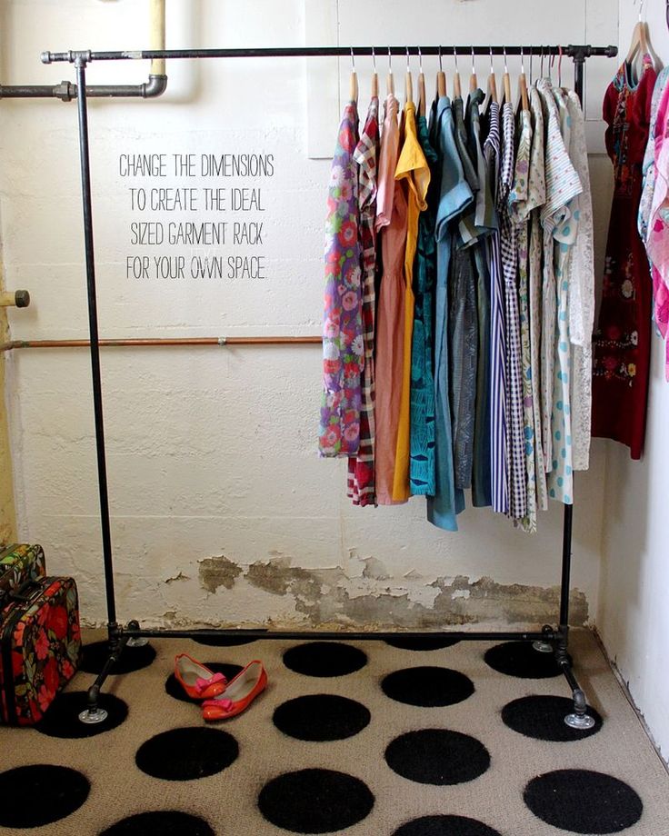 a closet with clothes hanging on racks and polka dot rugs in front of it