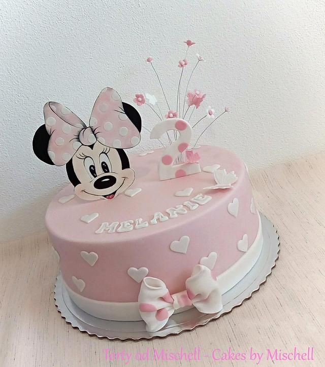 a minnie mouse cake with pink and white decorations