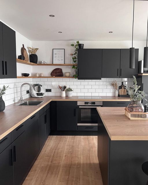 a kitchen with black cabinets and wooden counter tops