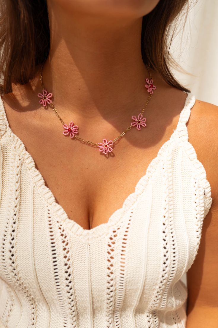 Fun and playful, this necklace features a variety of stylish beaded pink flowers on a shiny golden finish chain. Made with durable stainless steel, it is also adjustable for the perfect fit. Spring Flower-shaped Rose Gold Necklaces, Rose Gold Flower Necklace For Spring, Spring Rose Gold Flower Necklace, Adjustable Flower Shaped Necklace For Spring, Pink Choker Jewelry For Spring, Trendy Flower Necklace With Flower Charm Pendant, Trendy Flower Necklace With Flower Pendant, Summer Pink Flower Beaded Necklaces, Trendy Flower Pendant Necklace With Charm