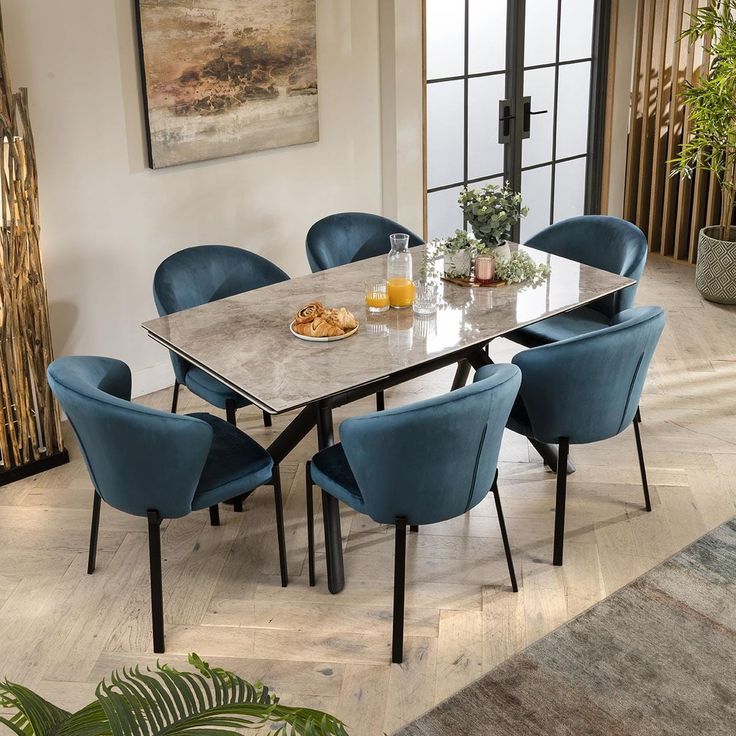 a dining room table with blue chairs around it