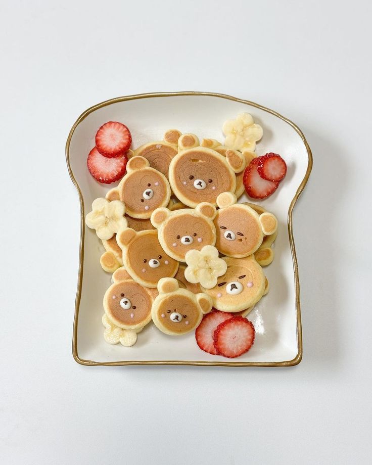 a white plate topped with pancakes and sliced strawberries