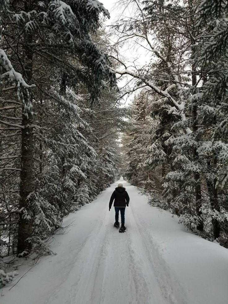 a person walking down a snow covered road