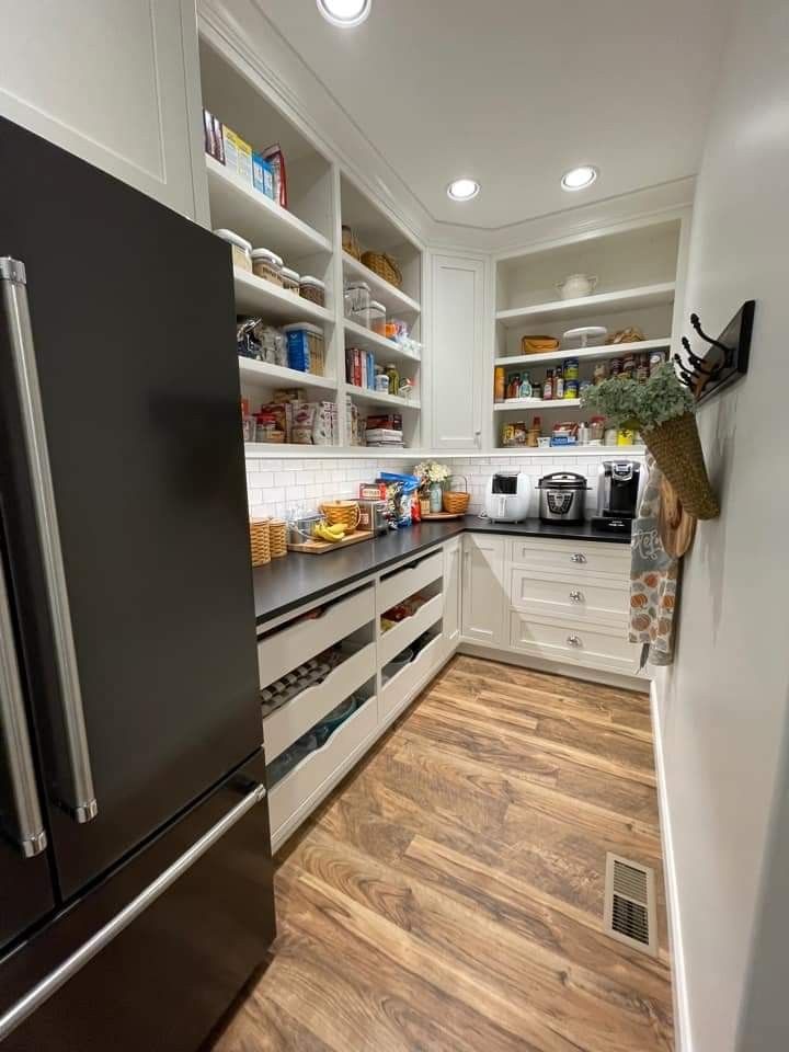 a kitchen with wooden floors and white cabinets