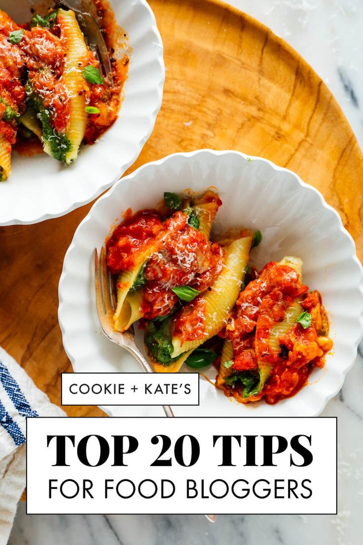 two white bowls filled with pasta and sauce on top of a wooden tray next to another bowl