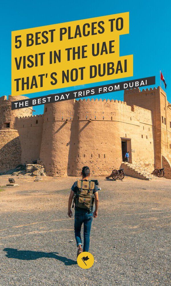 a man walking in front of a castle with a yellow sign that says 5 best places to visit in the usa that's not dubai