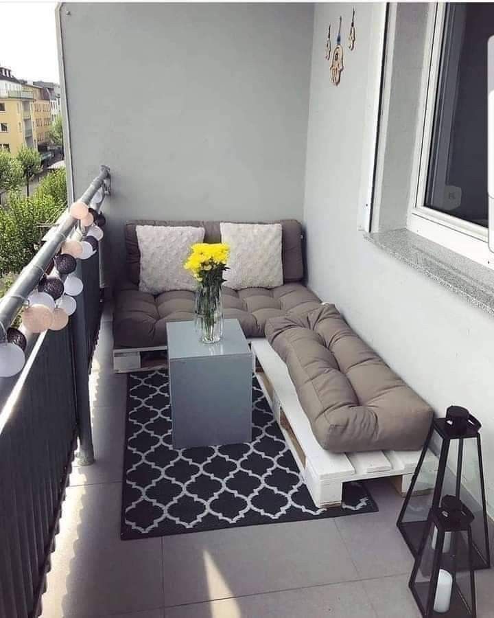 a living room with a couch and table on the balcony