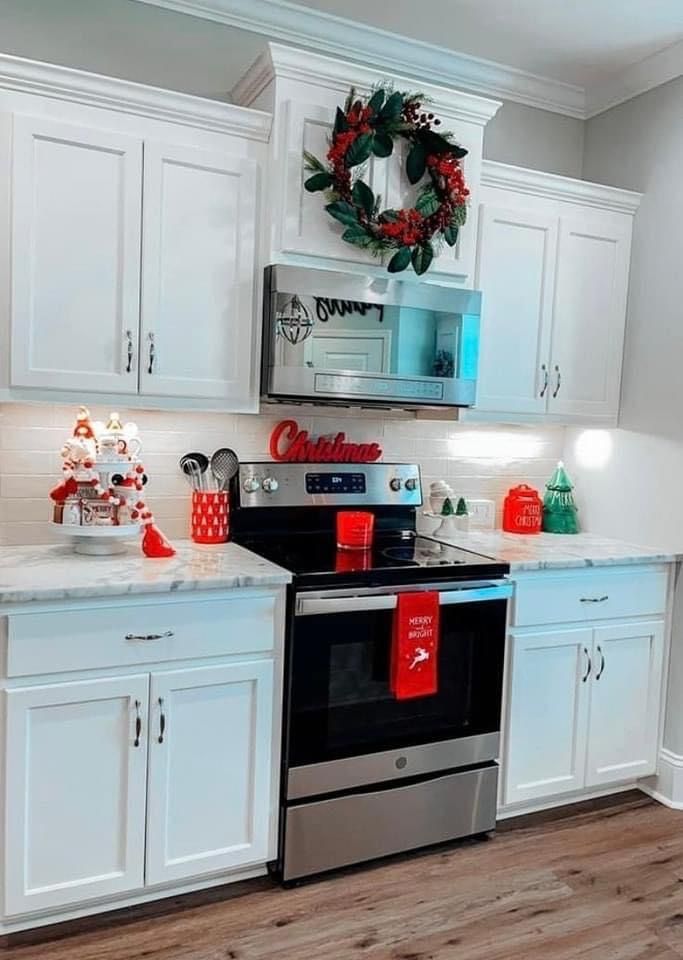 a kitchen with white cabinets and christmas decorations