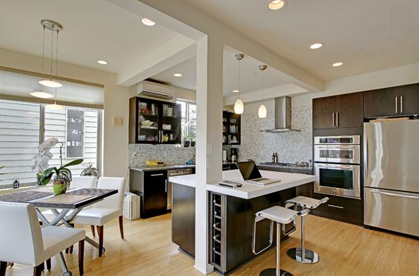 a modern kitchen with stainless steel appliances and wood flooring is pictured in this image